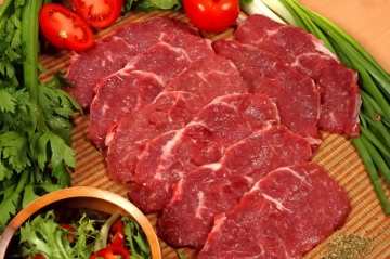 Beef meat pieces on wooden cutting board