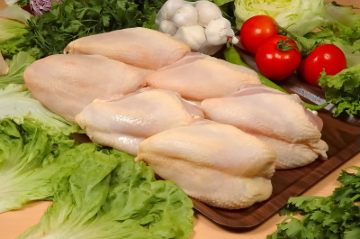 Chicken meat pieces on wooden cutting board